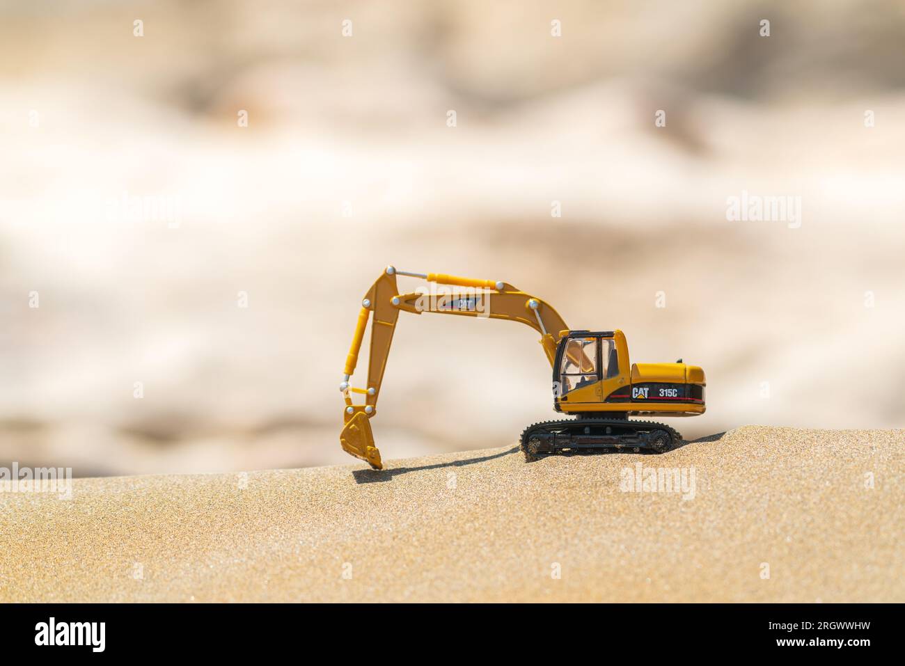 Caterpillar toy model excavator on sand in desert Stock Photo - Alamy