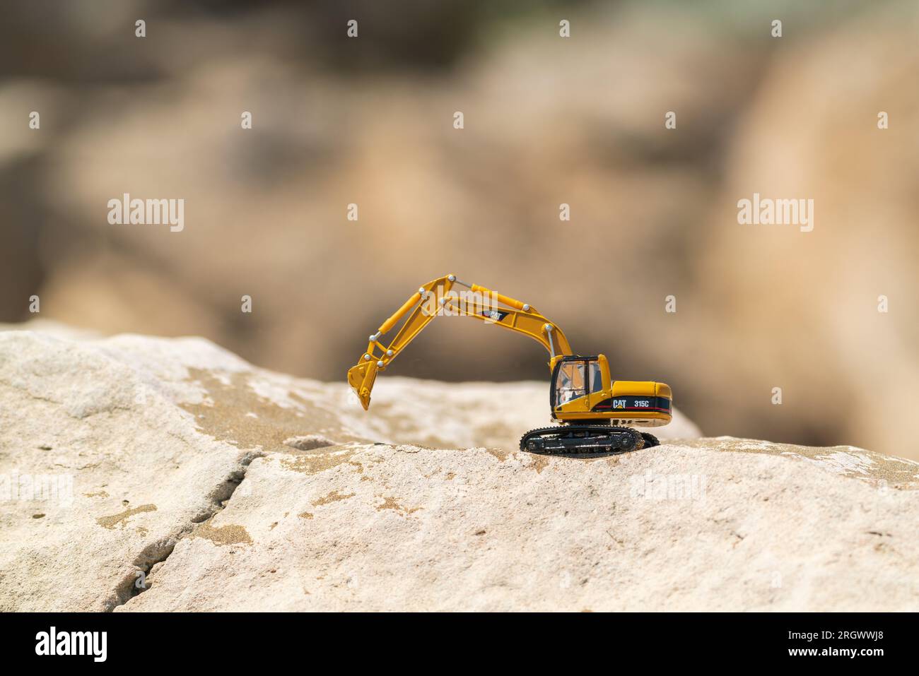 Caterpillar toy model excavator on sand in desert Stock Photo - Alamy