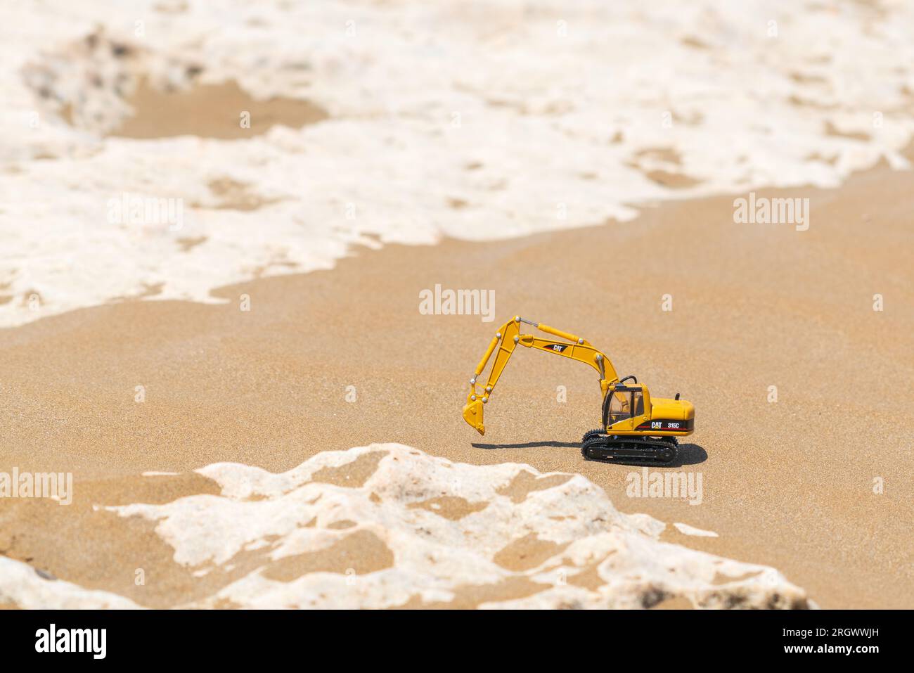 Caterpillar toy model excavator on sand in desert Stock Photo - Alamy