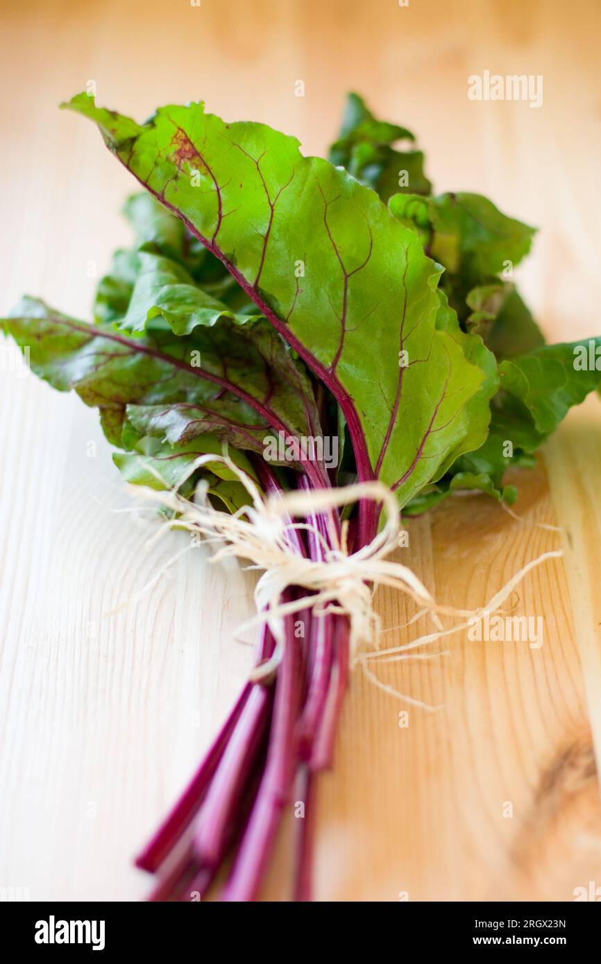 a bunch of red chard leaves on wooden  table Stock Photo