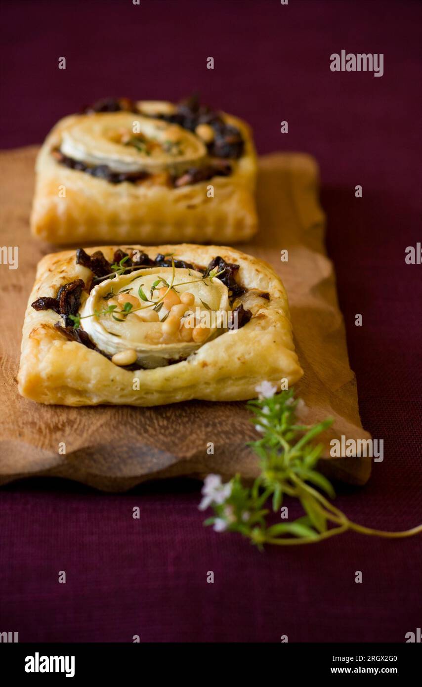 Small tarts with red onion ja ,goat cheese,pine nut and thyme Stock Photo