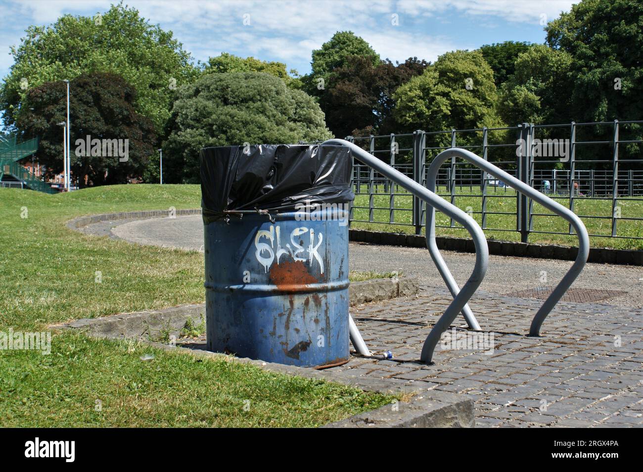 Trash can and bike shed in the park. A metal barrel as a trash can