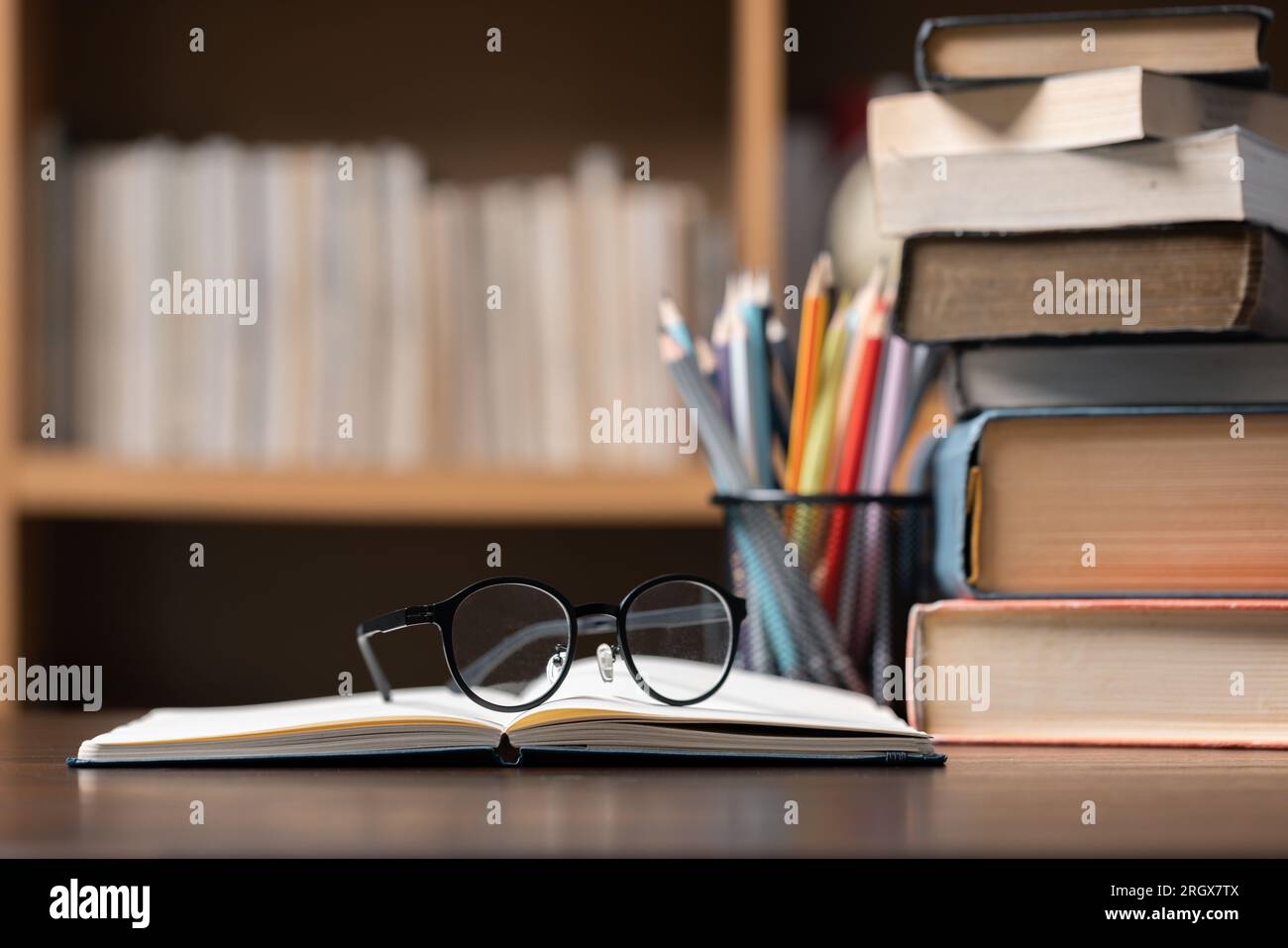 Education learning concept. Book in library with old open textbook, stack piles of literature text archive on reading desk, aisle of bookshelves in sc Stock Photo