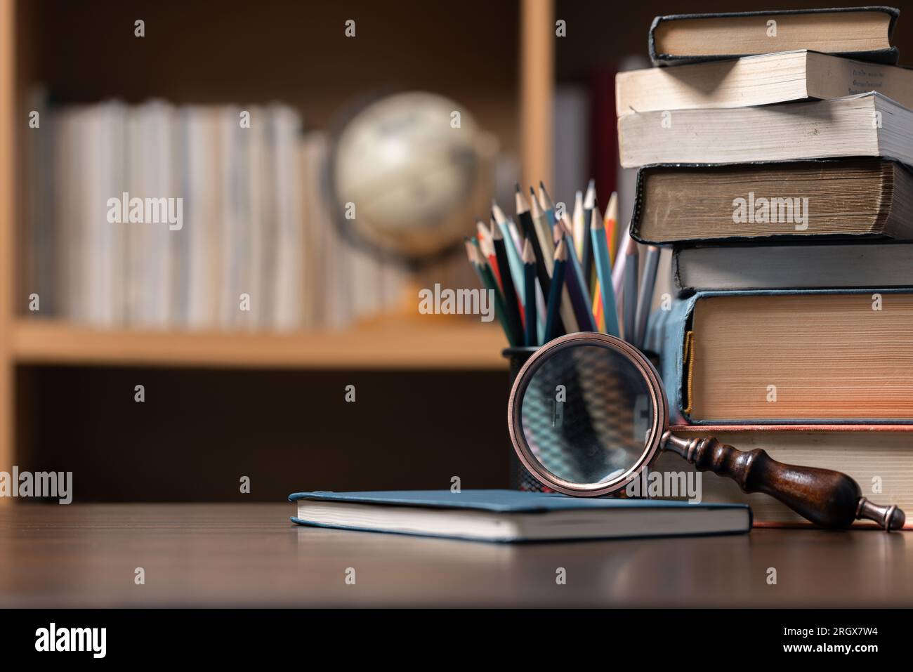 Education learning concept. Book in library with old open textbook, stack piles of literature text archive on reading desk, aisle of bookshelves in sc Stock Photo