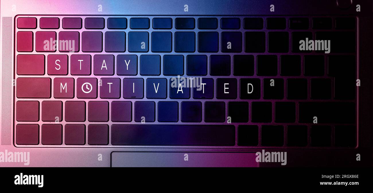 Flat lay photo of close up laptop keyboard with stay motivated quote on