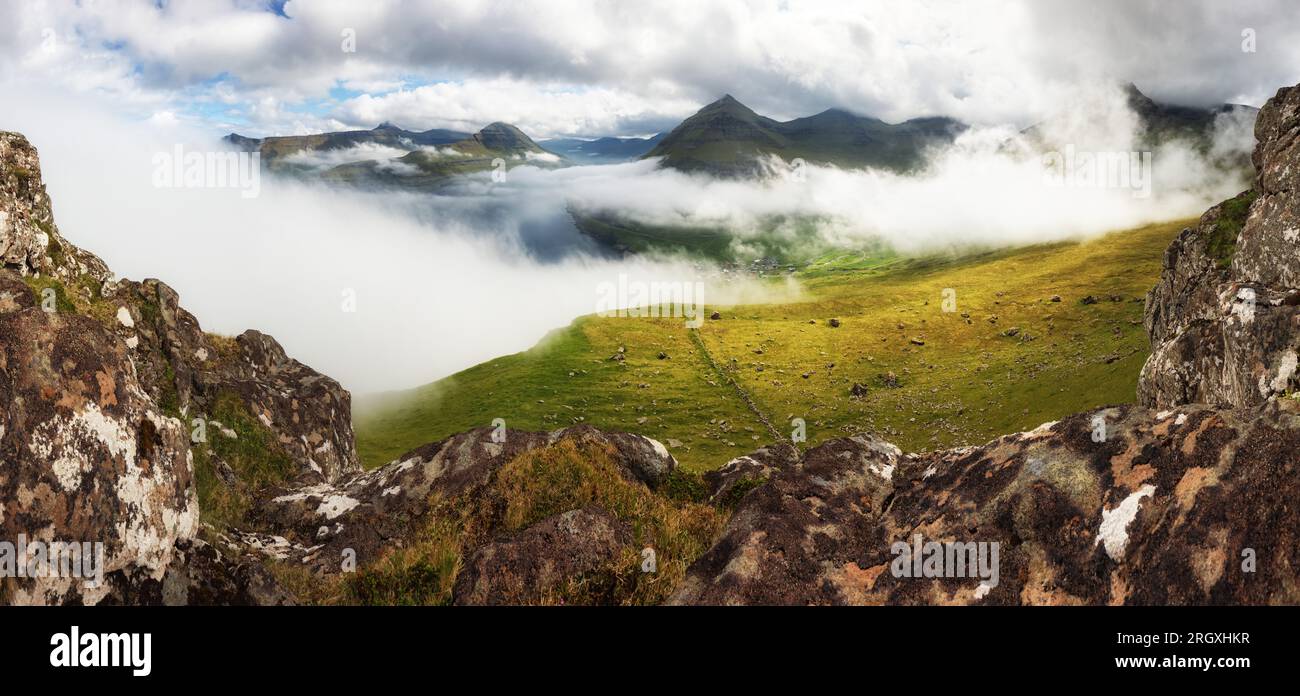 Panorama of spectacular mountains and fjords near the village of Funningur from the Hvithamar mountain in Faroe Islands, Denmark. Stock Photo