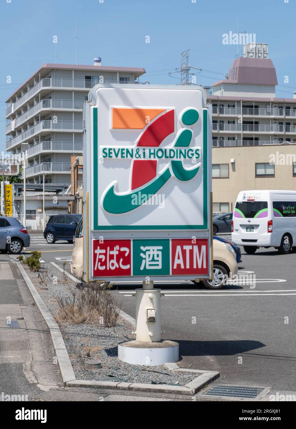 A 7-Eleven sign with 7 and i Holdings as well cigarettes, alcohol, and ATM written on the sign. Stock Photo