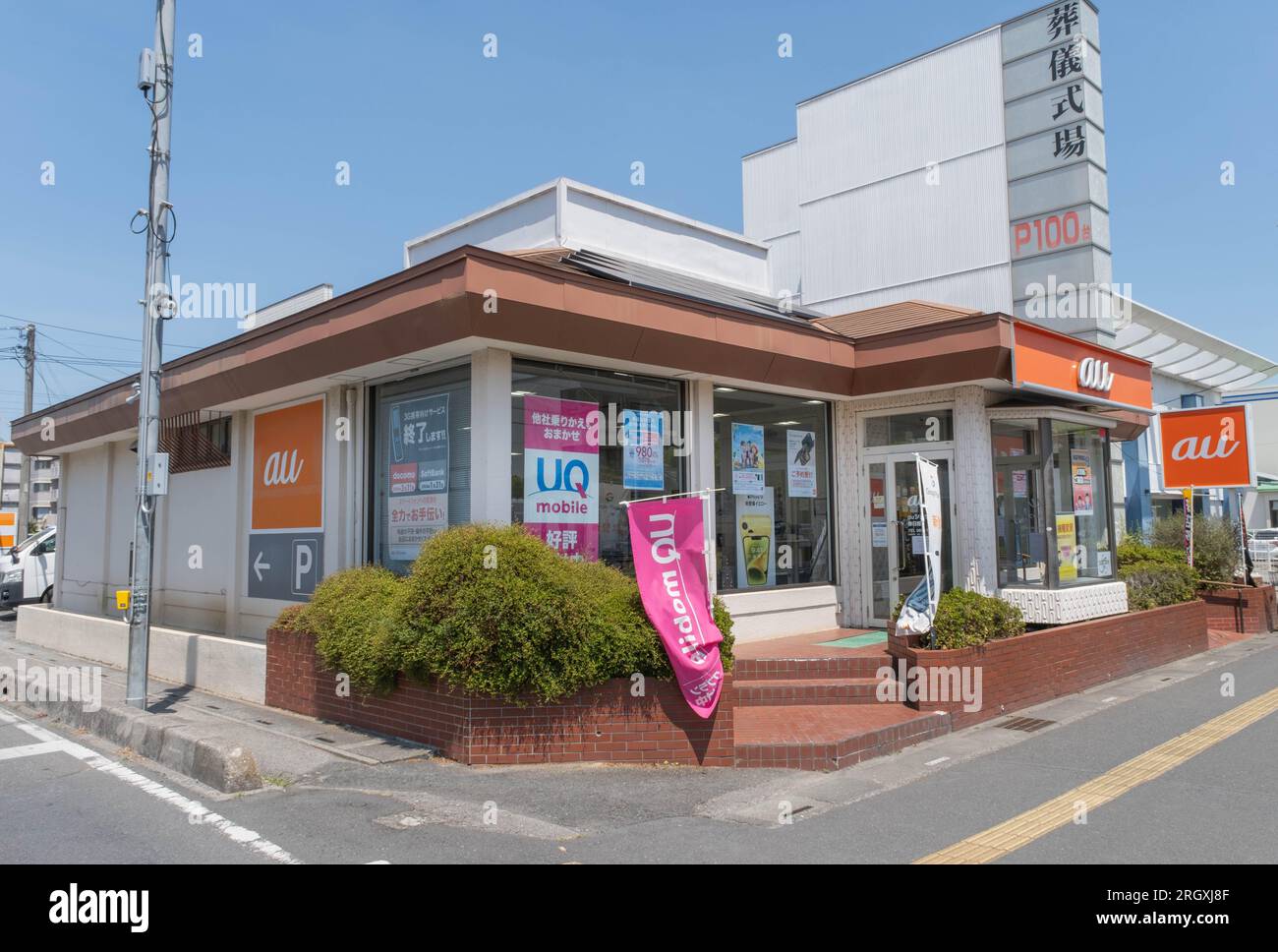 A storefront shot of an au cell phone or mobile phone shop located on the corner of a busy intersection. Stock Photo