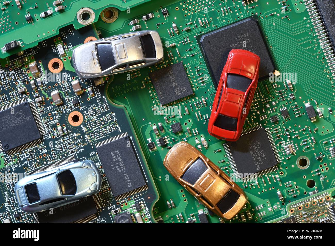 Toy cars on electronic board and microchip. Conceptual image for