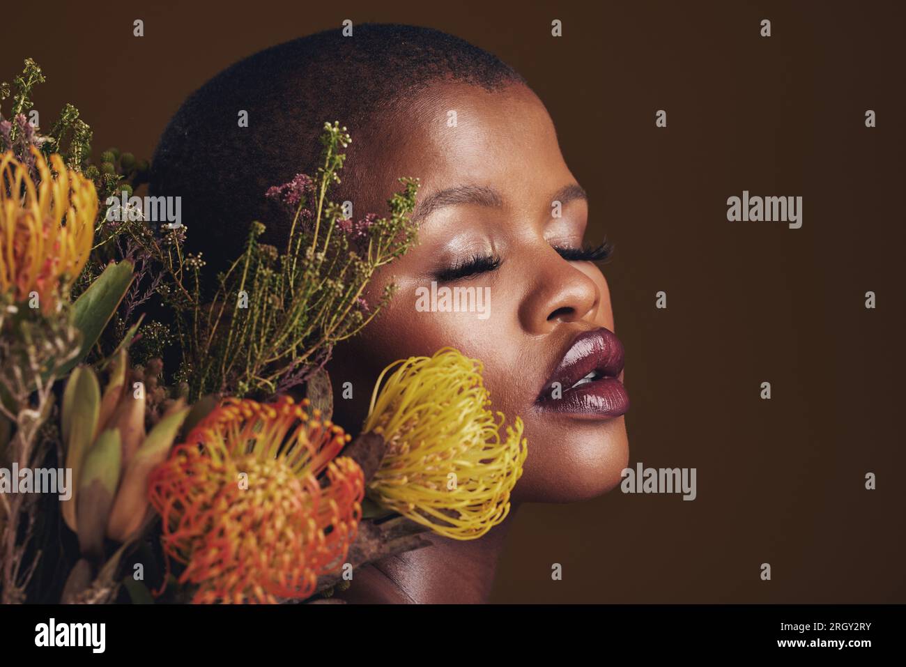 Black woman, flowers and makeup in studio for beauty, wellness or ...