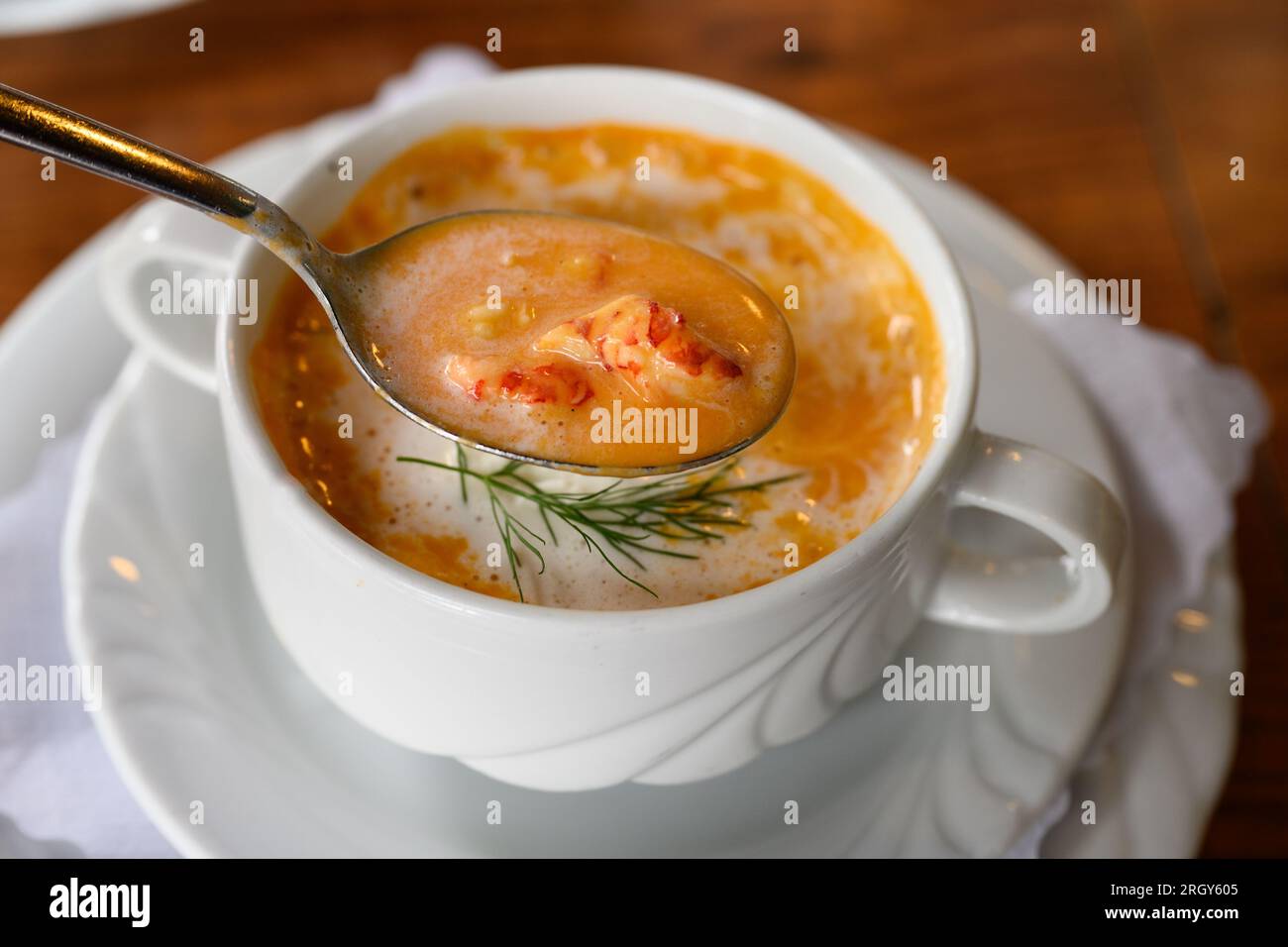 Busumer Krabbensuppe, Busom Style Soup with North Sea Crabs or Brown Shrimps on a Spoon in a White Bowl Stock Photo