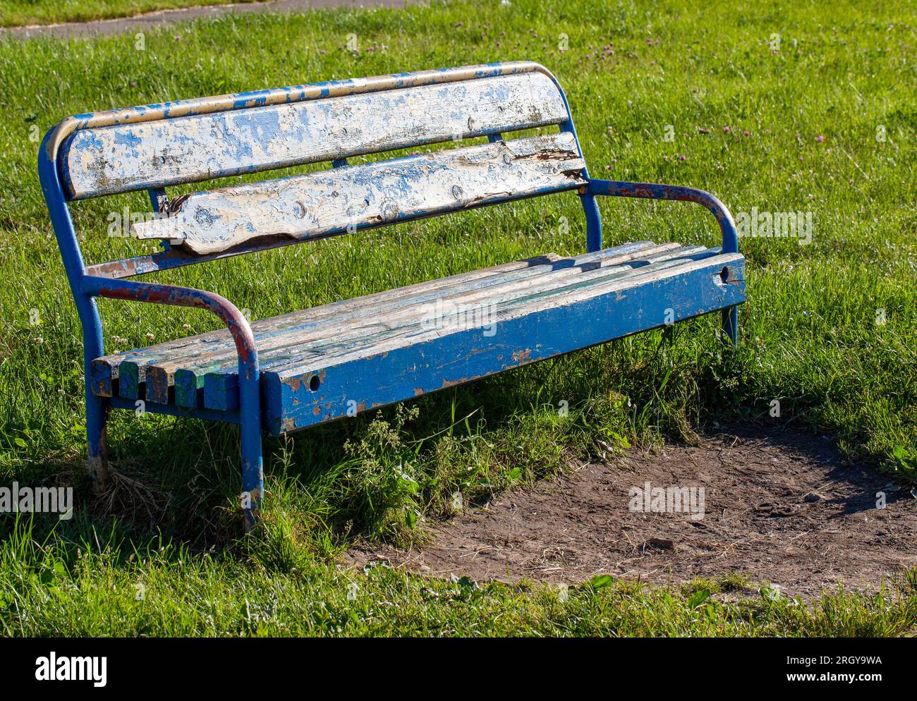 an old bench with stripped paint in the park, an old not repaired bench ...