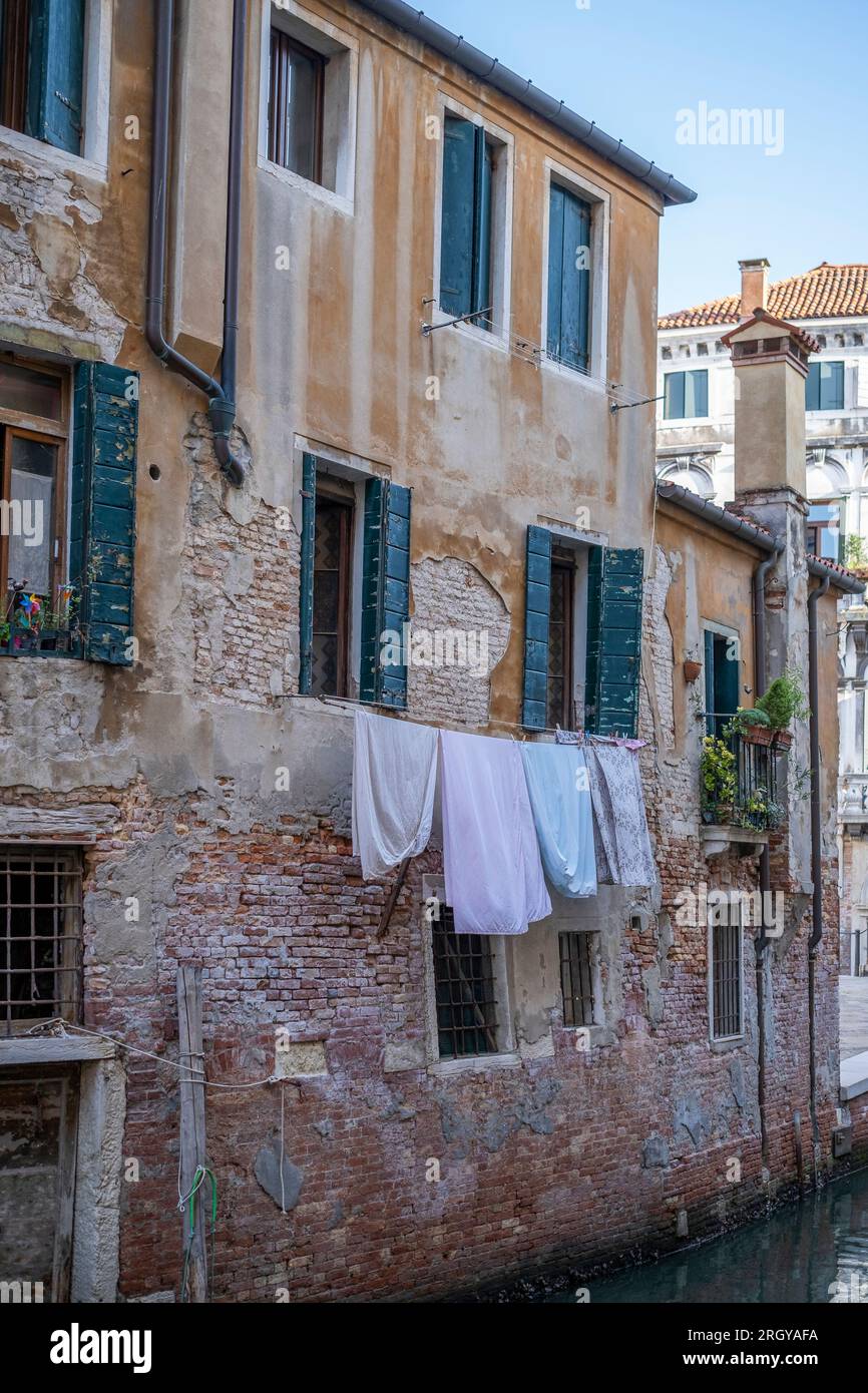 Laundry hanging out to dry on ropes over canal in Venice Stock Photo