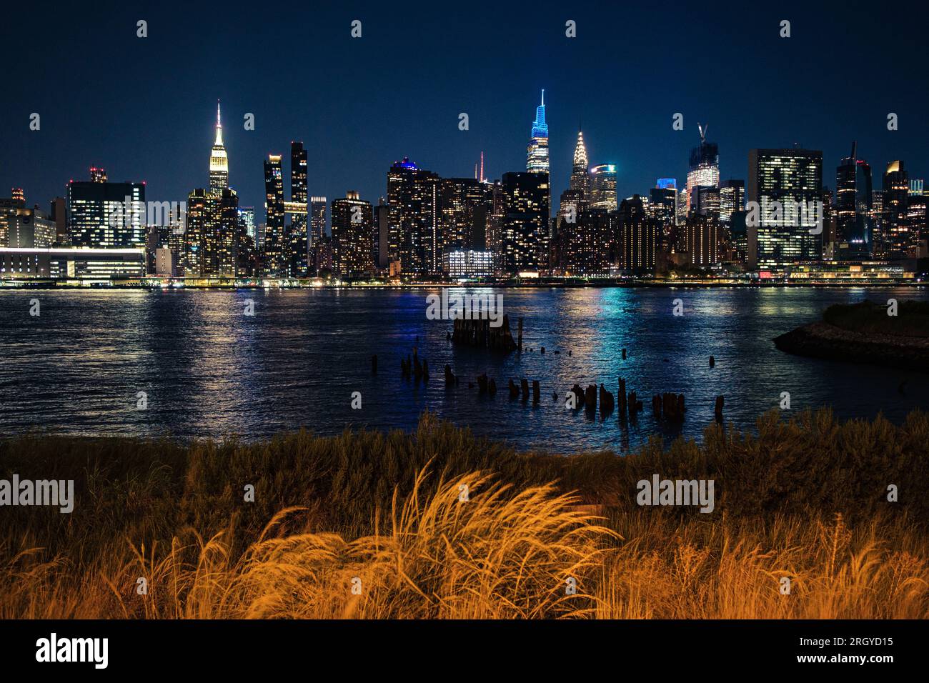 Manhattan skyline at night from Long Island City. City lights reflecting on the East River on a clear summer evening Stock Photo