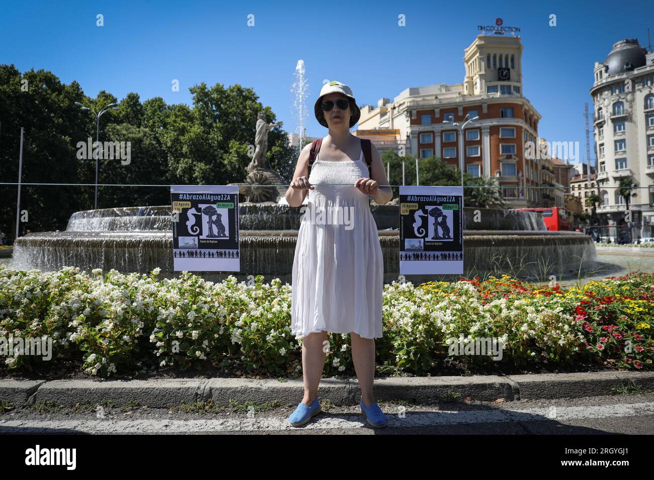 Madrid, Spain. 12th Aug, 2023. An activist carries placards during the rally in front of the Neptune fountain. Nearly a hundred people have gathered at the Neptune fountain in Madrid under the slogan 'Hug the Mar Menor', to create a human chain with the aim of defending the 'limit situation' that the Maditerraneo is experiencing. Credit: SOPA Images Limited/Alamy Live News Stock Photo