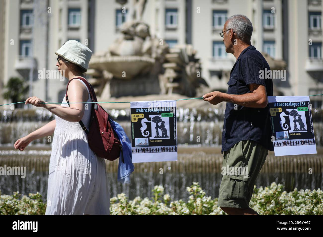 Madrid, Spain. 12th Aug, 2023. Activists march during a rally in front of the Neptune fountain. Nearly a hundred people have gathered at the Neptune fountain in Madrid under the slogan 'Hug the Mar Menor', to create a human chain with the aim of defending the 'limit situation' that the Maditerraneo is experiencing. (Photo by David Canales/SOPA Images/Sipa USA) Credit: Sipa USA/Alamy Live News Stock Photo