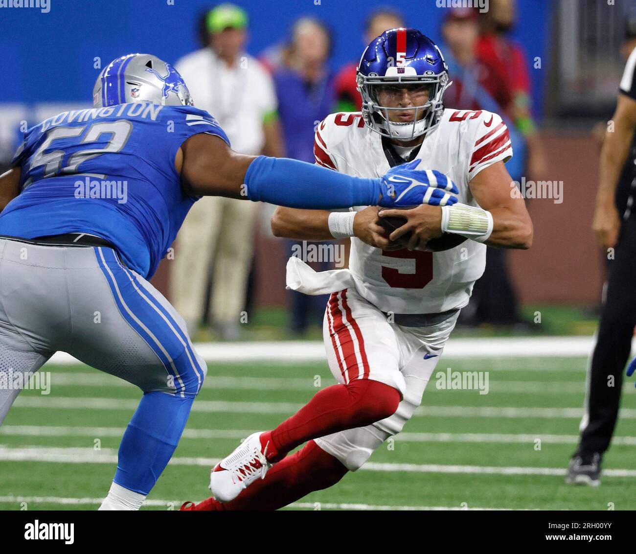 New York Giants quarterback Tommy DeVito (5) avoids Detroit Lions defensive  tackle Christian Covington (52) while carrying the ball during the first  half of an NFL preseason football game, Friday, Aug. 11,