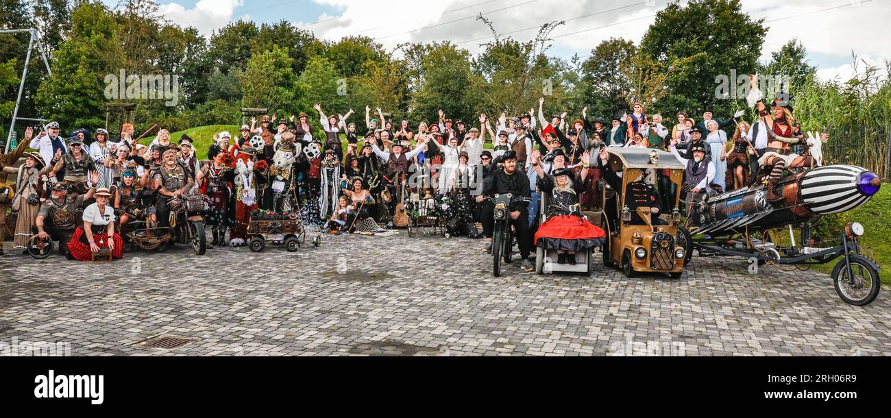 Henrichenburg, Waltrop, Germany. 12th Aug, 2023. The obligatory group photo units many of today's participants and groups. Steampunk fans, groups in costumes and visitors, many in retro-futuristic or Victorian inspired outfits, have fun despite the heavy rain showers on day one of the Steampunk Jubilee Festival weekend at the historic Henrichenburg boat lift, a listed architectural landmark and industrial heritage site. Credit: Imageplotter/Alamy Live News Stock Photo