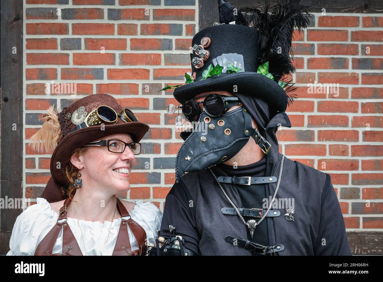 Henrichenburg, Waltrop, Germany. 12th Aug, 2023. Darksteam the Pest Doctor poses with his companion. Steampunk fans, groups in costumes and visitors, many in retro-futuristic or Victorian inspired outfits, have fun despite the heavy rain showers on day one of the Steampunk Jubilee Festival weekend at the historic Henrichenburg boat lift, a listed architectural landmark and industrial heritage site. Credit: Imageplotter/Alamy Live News Stock Photo