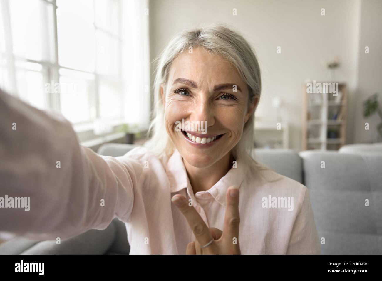 Happy positive blonde senior woman taking selfie picture Stock Photo