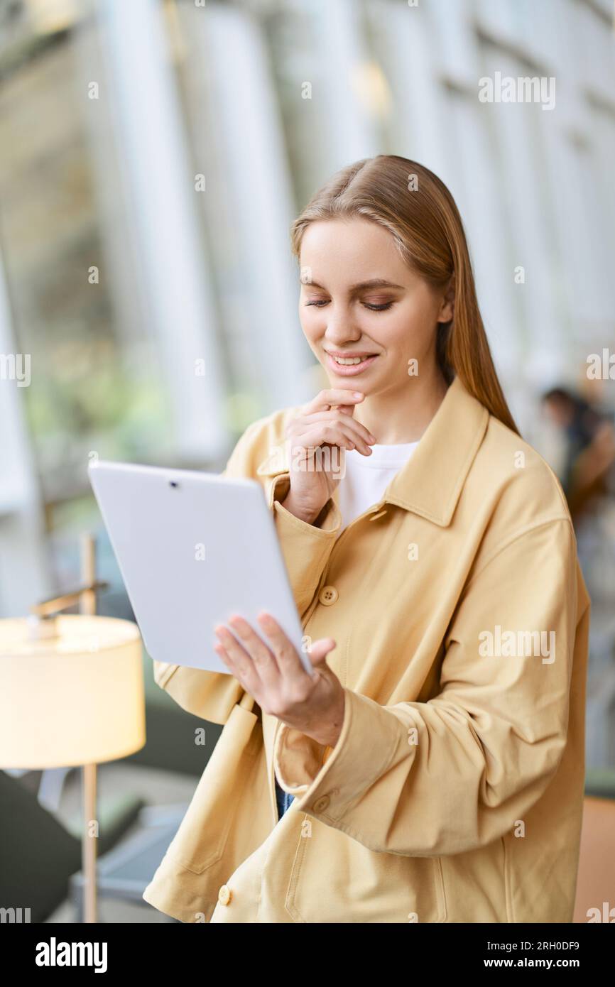 Happy girl student using digital tablet modern tech device. Vertical shot Stock Photo