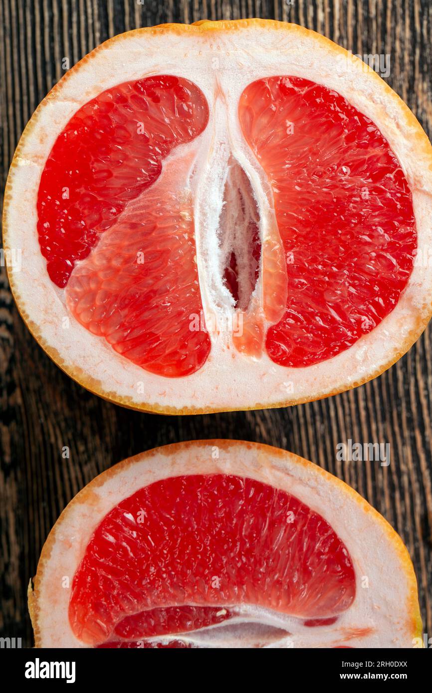 ripe red grapefruit, sliced and sliced into pieces, grapefruit with juicy red-pink flesh is cut into pieces Stock Photo