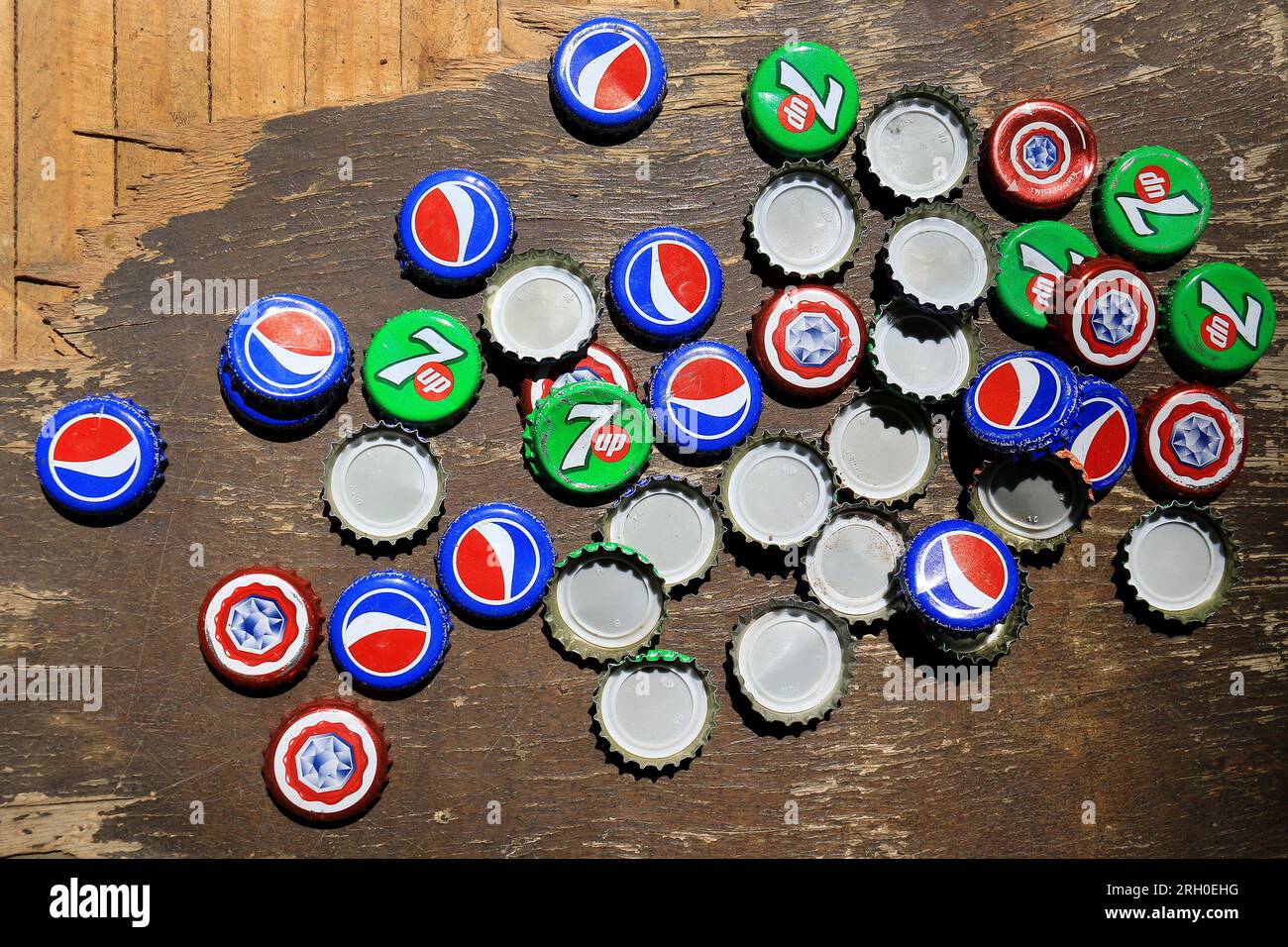Caps of pepsi cola, 7Up, and Almaza beer on a table. Stock Photo