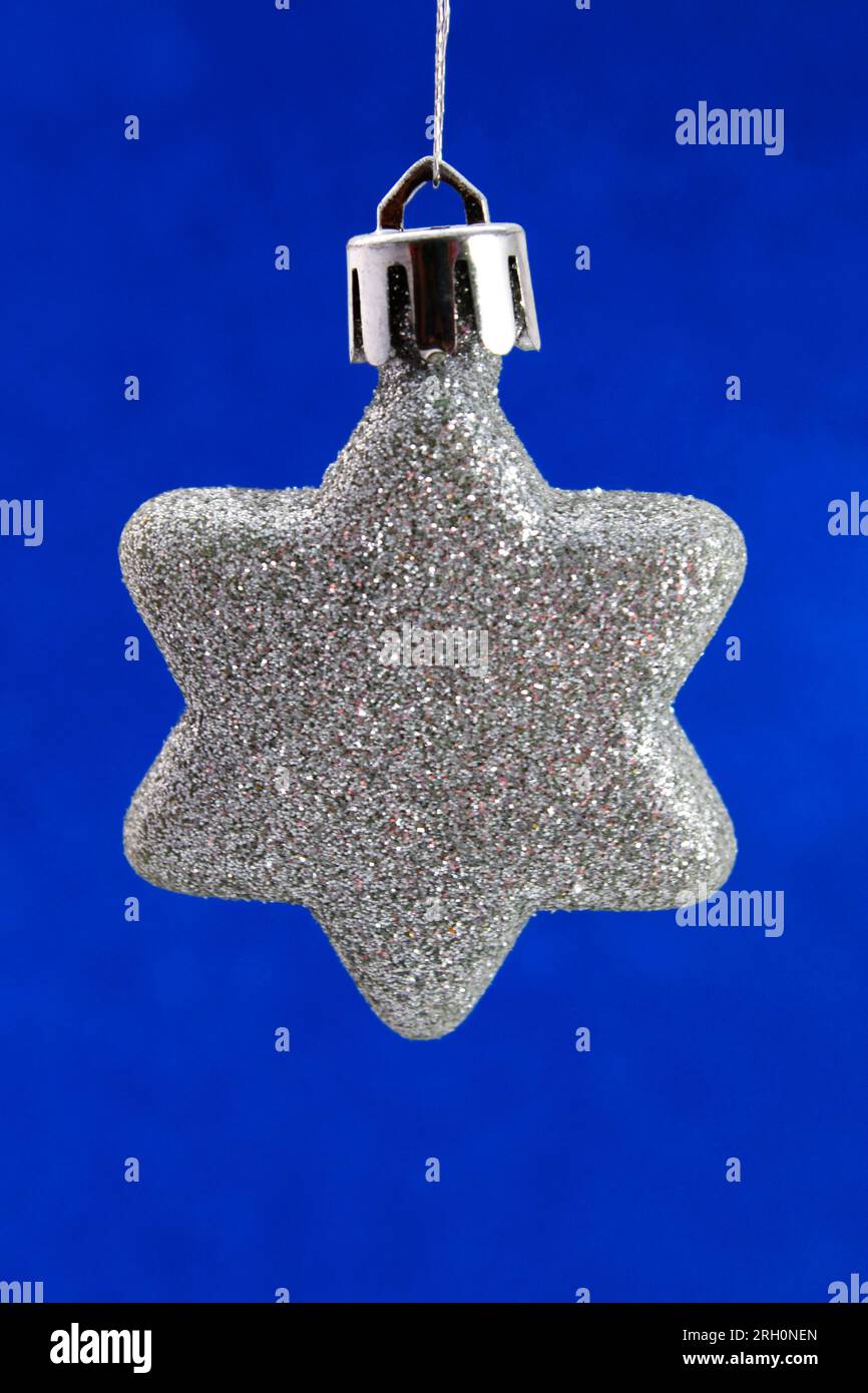 Silver glitter star on blue background, christmas ornament Stock Photo