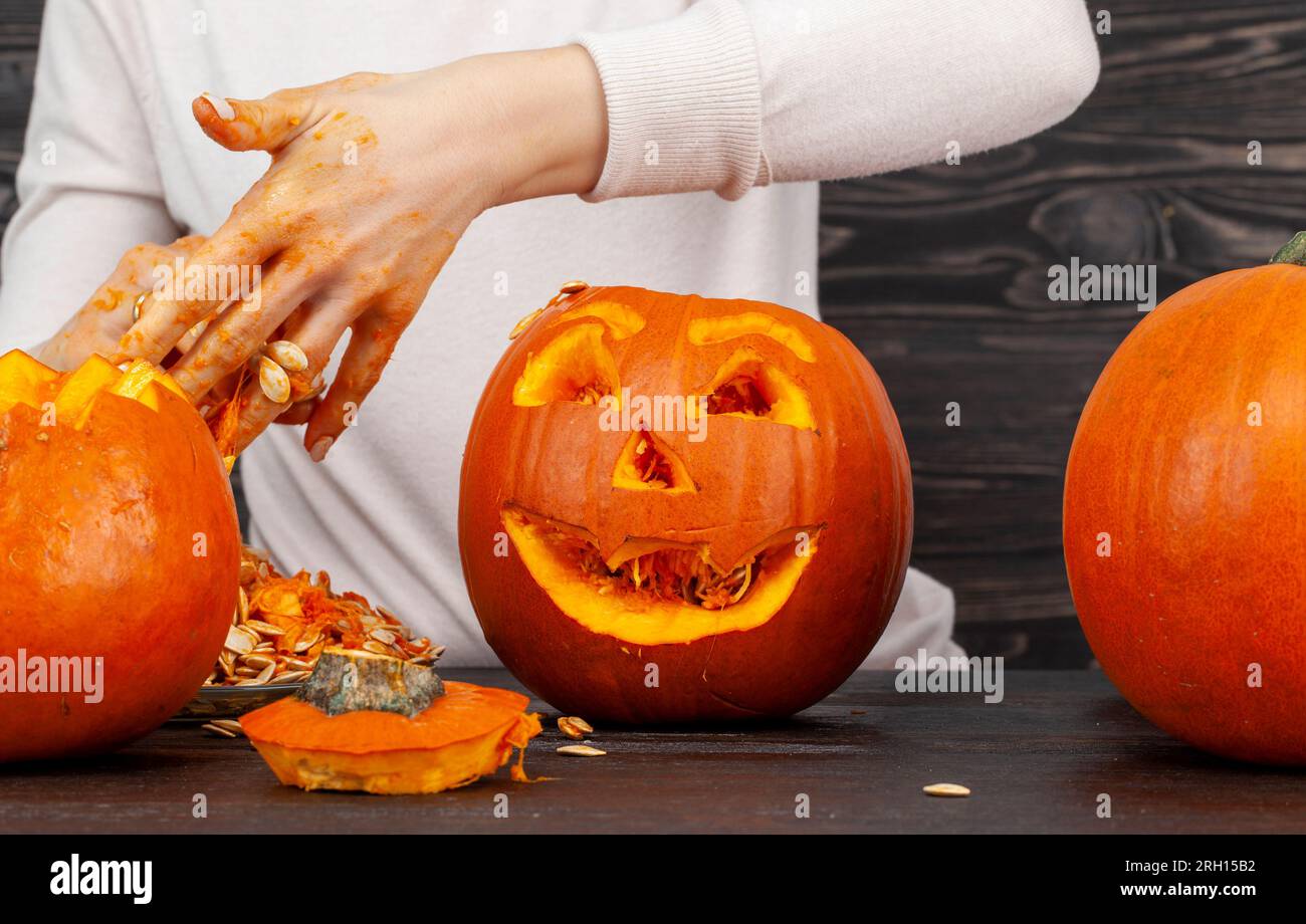 preparing orange pumpkins for Halloween celebration, carved from small ...