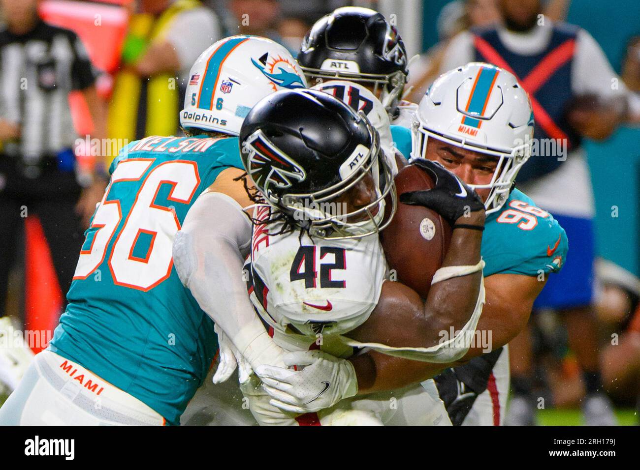 Atlanta Falcons quarterback Logan Woodside (11) is hit by Miami Dolphins  linebacker Garrett Nelson (56) in the first half of a preseason NFL  football game, Friday, Aug. 11, 2023, in Miami Gardens