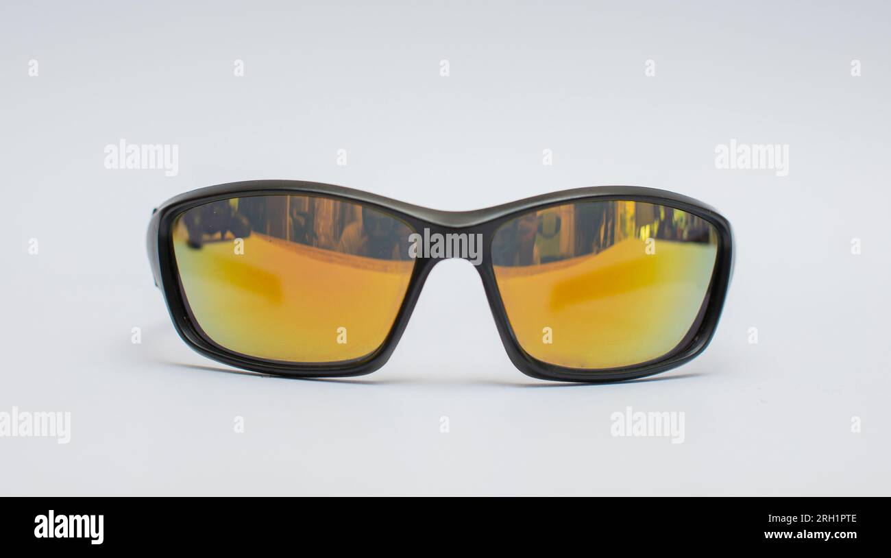 Black sunglasses with yellow-orange glass lenses isolated on white background. Stock Photo