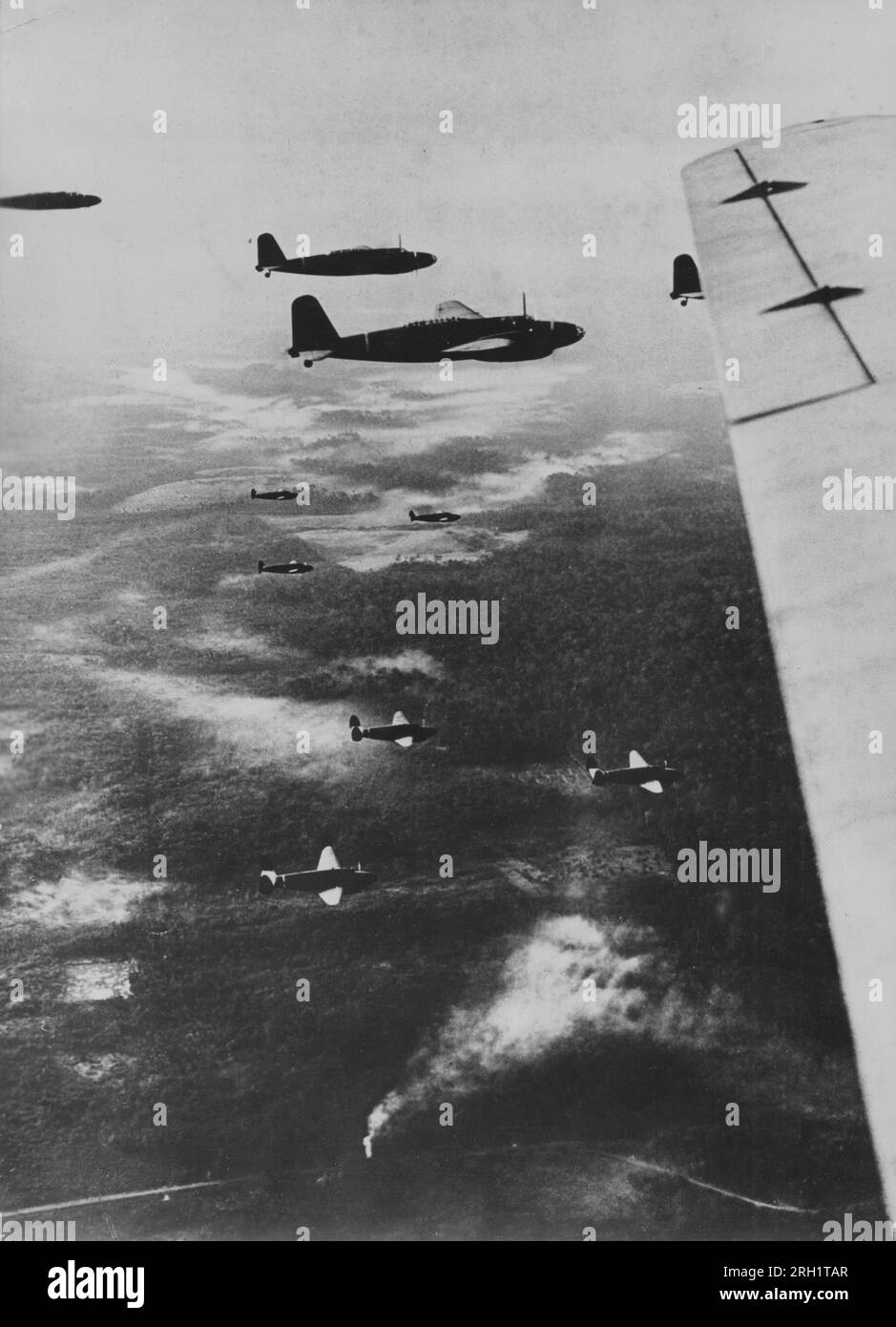 Battle of Palembang, February 13-15 1942. Imperial Japanese Army transport aircraft carrying paratroopers from the ‘Teishin Shudan’ (Raiding Group) in the skies above Musi River, Sumatra advance towards their target destination of Palembang, February 1942. Stock Photo