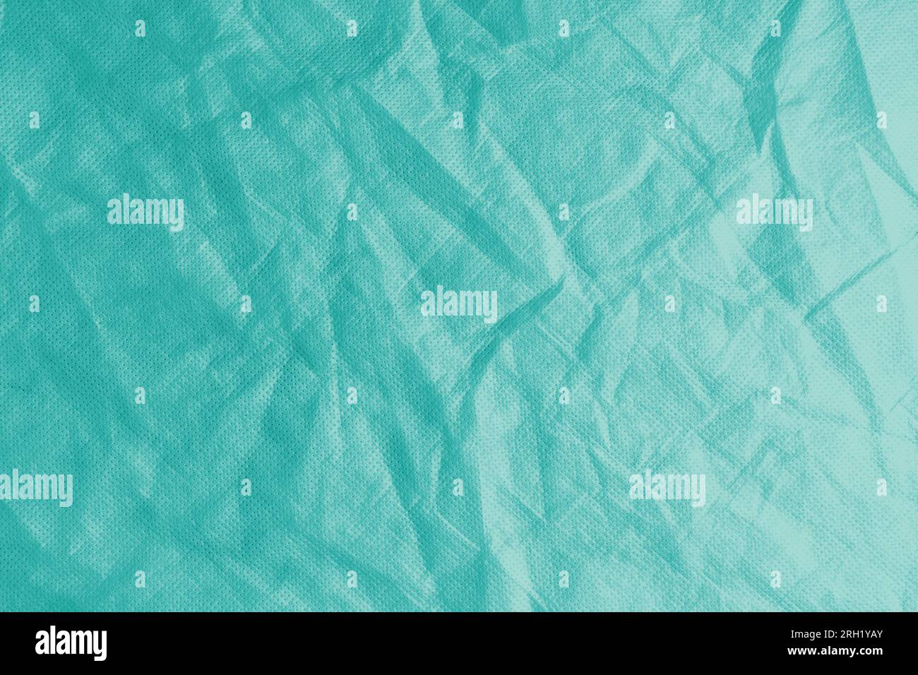 Wrinkled, crumpled turquoise fabric texture background. Wrinkled and