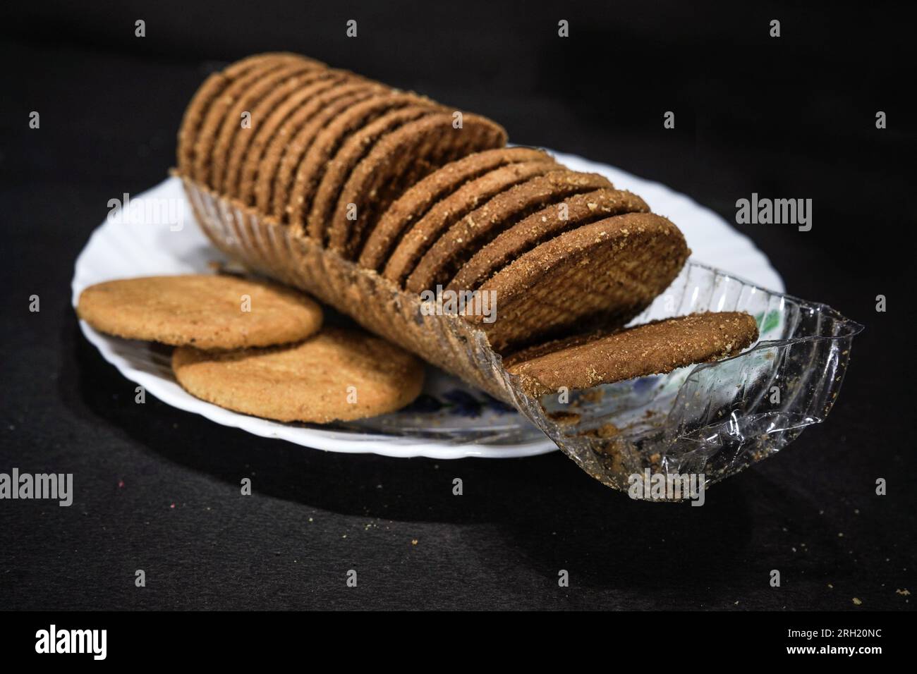 Wheat biscuits in the white melamine plate with black background. Indian biscuits popularly