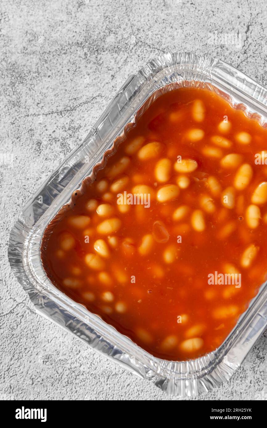 Baked beans, in a tomato sauce, in a takeaway foil tray carton
