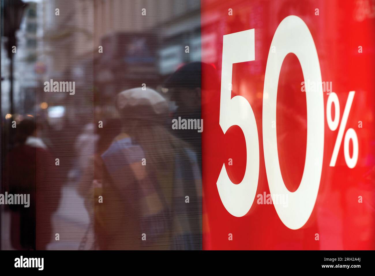 50 percent discount sign against crowd reflected in a store window Stock Photo