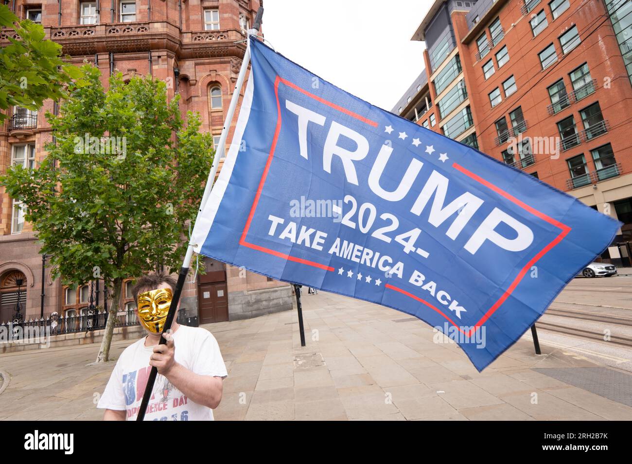 Manchester, UK. 12th Aug, 2023. Pro Trump 2024 supporter opposite a crowd of 80 people who turned up on 12th of August 2023 to mark the Peterloo massacre of 16th of August 1819 which took place in Manchester. Organisers blamed a rival 'Peterloo March for democracy' event which is organised for the 19th of August 2023, plus other protests and events including the Manchester Caribbean carnival, a Trans right protest and a Iranian proregime change protest in St Peters square Manchester. The small crowd marched to the Peterloo Massacre memorial in central Manchester. In attendance was climate chan Stock Photo