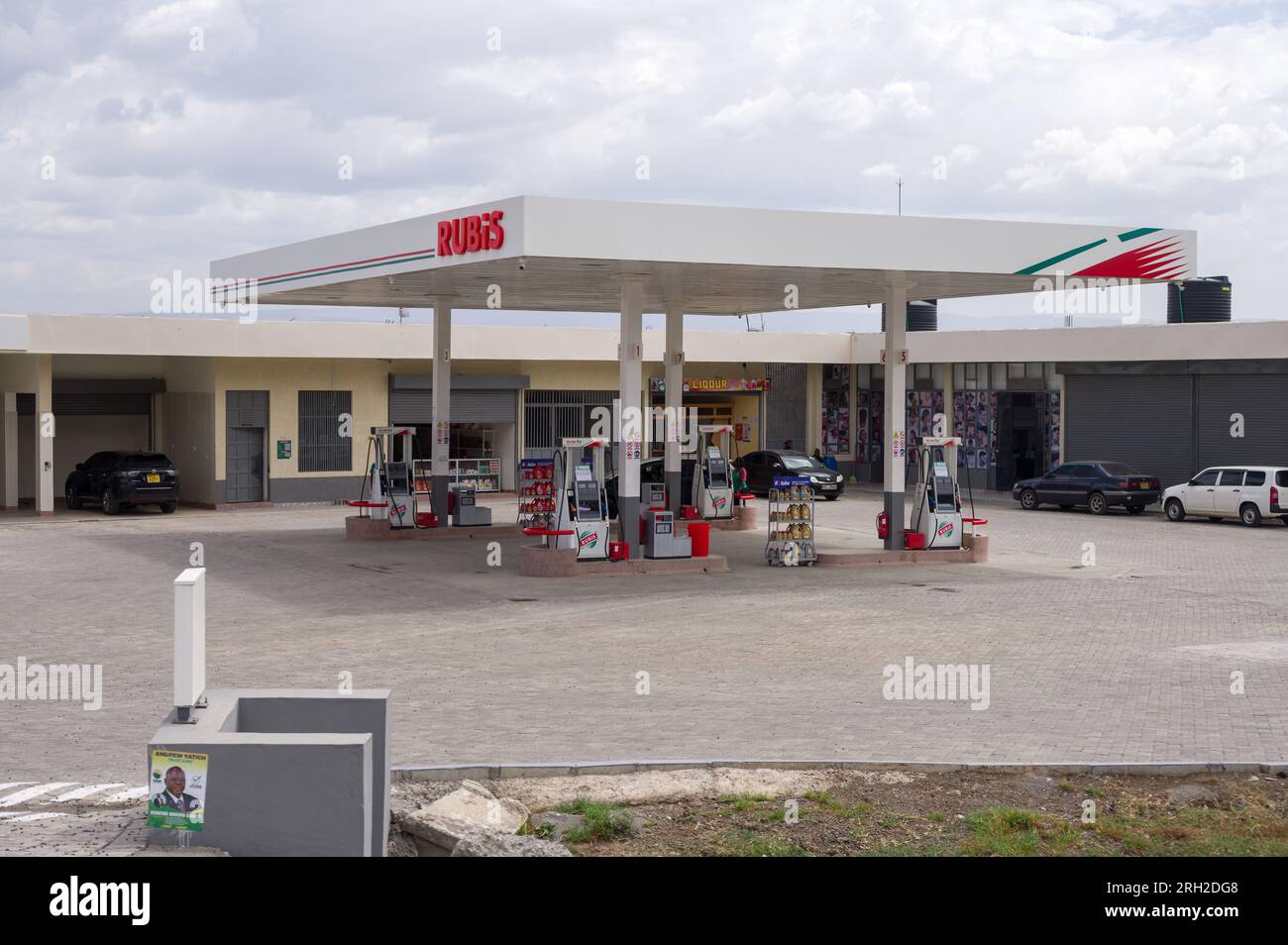 Exterior of a Rubis petrol fuel station with pumps and vehicles parked nearby, Nakuru, Kenya Stock Photo