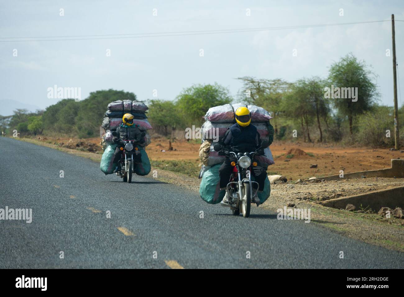 Two boda boda motorbike riders carrying sacks of charcoal on the back of their motorcycles, Nakuru, Kenya, East Africa Stock Photo