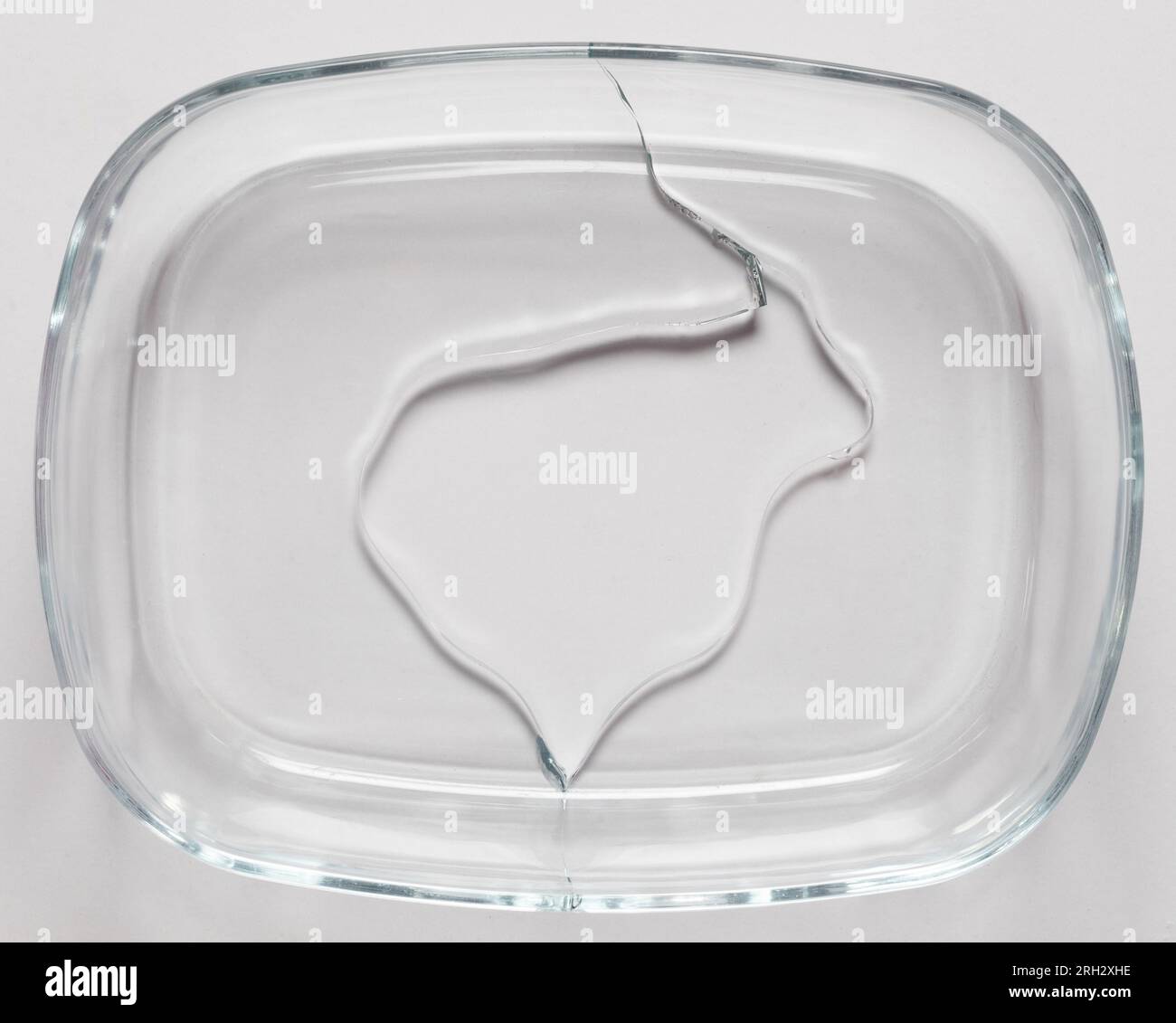 Broken glass dish with crack isolated on white studio background Stock