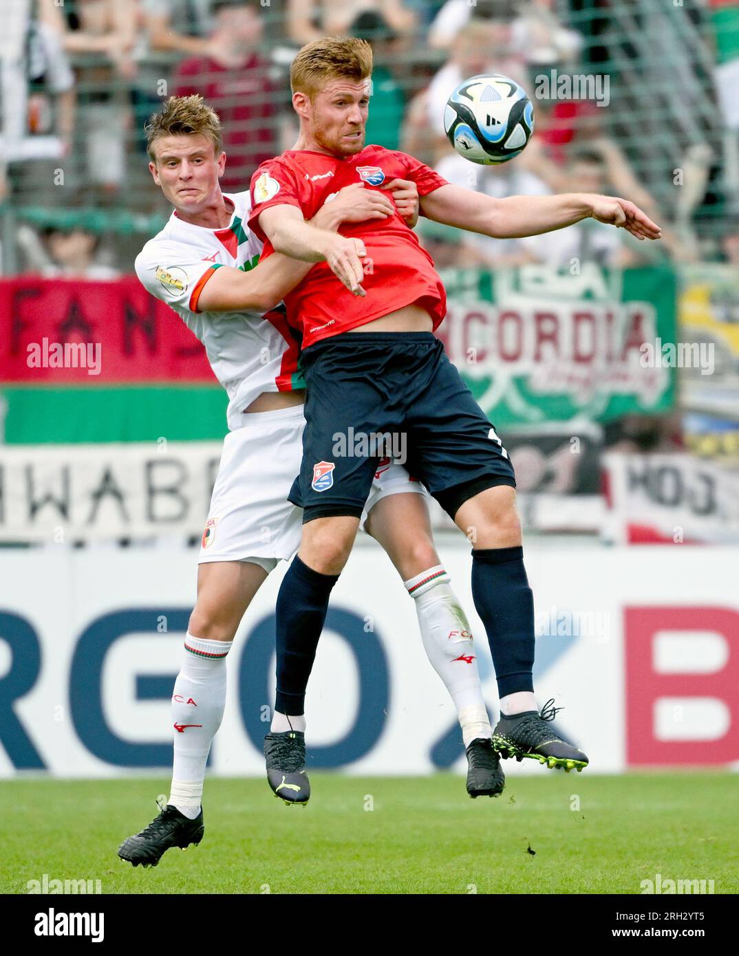 Unterhaching, Germany. 13th Aug, 2023. Soccer: DFB Cup, SpVgg Unterhaching - FC Augsburg, 1st round at Sportpark Unterhaching. Mathias Fetsch (r) of Unterhaching and Frederik Winther of Augsburg fight for the ball. Credit: Sven Hoppe/dpa - IMPORTANT NOTE: In accordance with the requirements of the DFL Deutsche Fußball Liga and the DFB Deutscher Fußball-Bund, it is prohibited to use or have used photographs taken in the stadium and/or of the match in the form of sequence pictures and/or video-like photo series./dpa/Alamy Live News Stock Photo