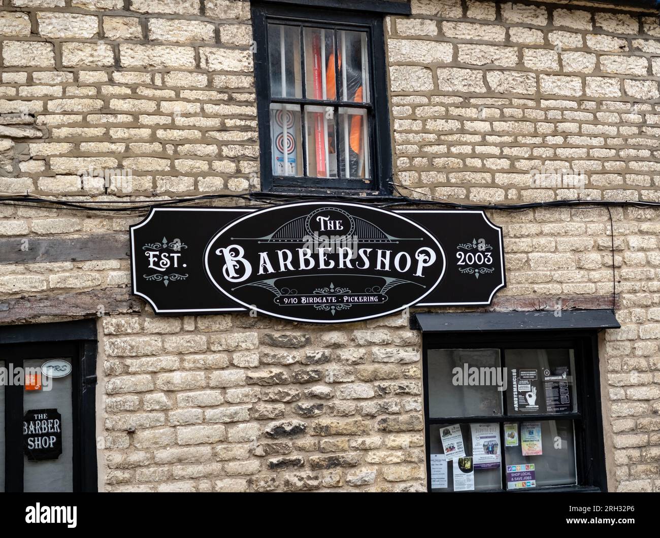 The barber sign on the outside wall of a men's hair salon in the North Yorkshire town of Pickering Stock Photo