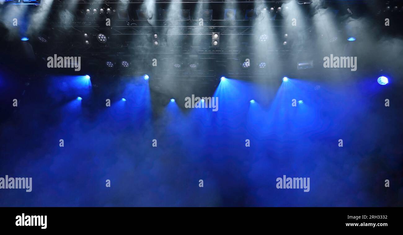 abstract background of stage lights with a blue and white ceiling spotlights and Stage mist working during the concert Stock Photo