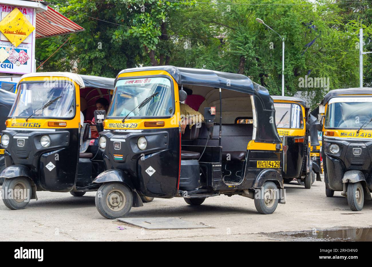 MUMBAI - SEPT 24: Traditional Black and Yellow Auto rickshaw or Tuk-Tuk waiting for passengers in a street in Mumbai on September 24. 2022, India Stock Photo