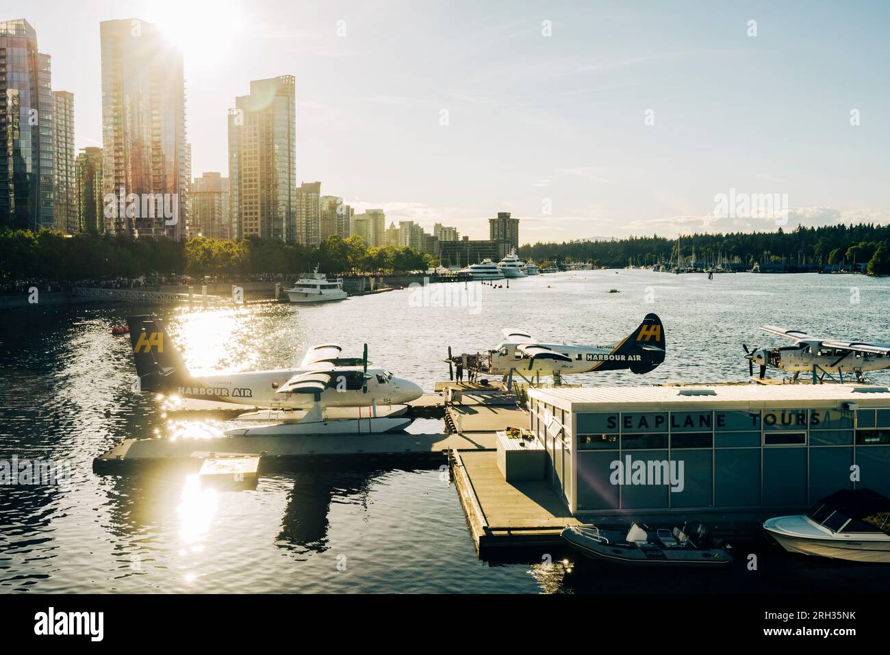 Float planes are moored at the jetty with the skyscrapers of Vancouver in the background in Canada Stock Photo