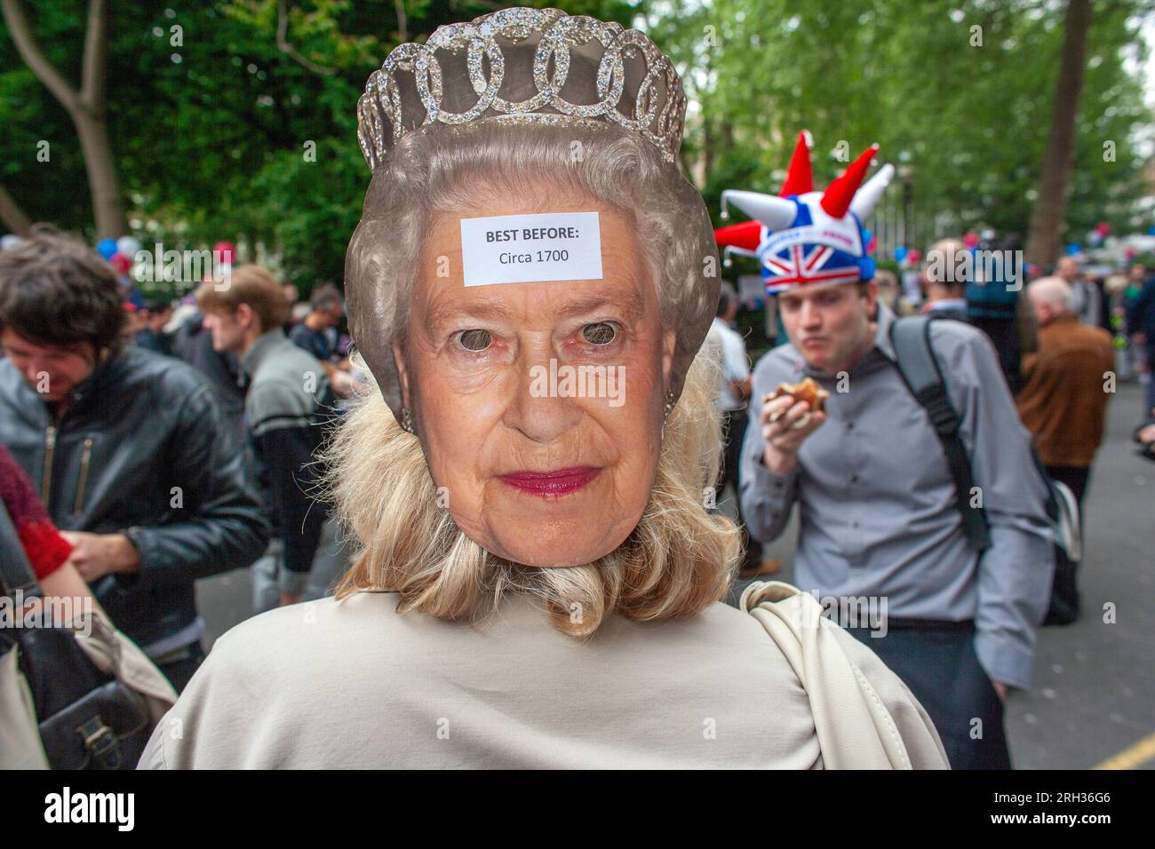 Anti-monarchy demonstrator wearing Queen mask protests during Royal weeding day celebrations. London, UK Stock Photo