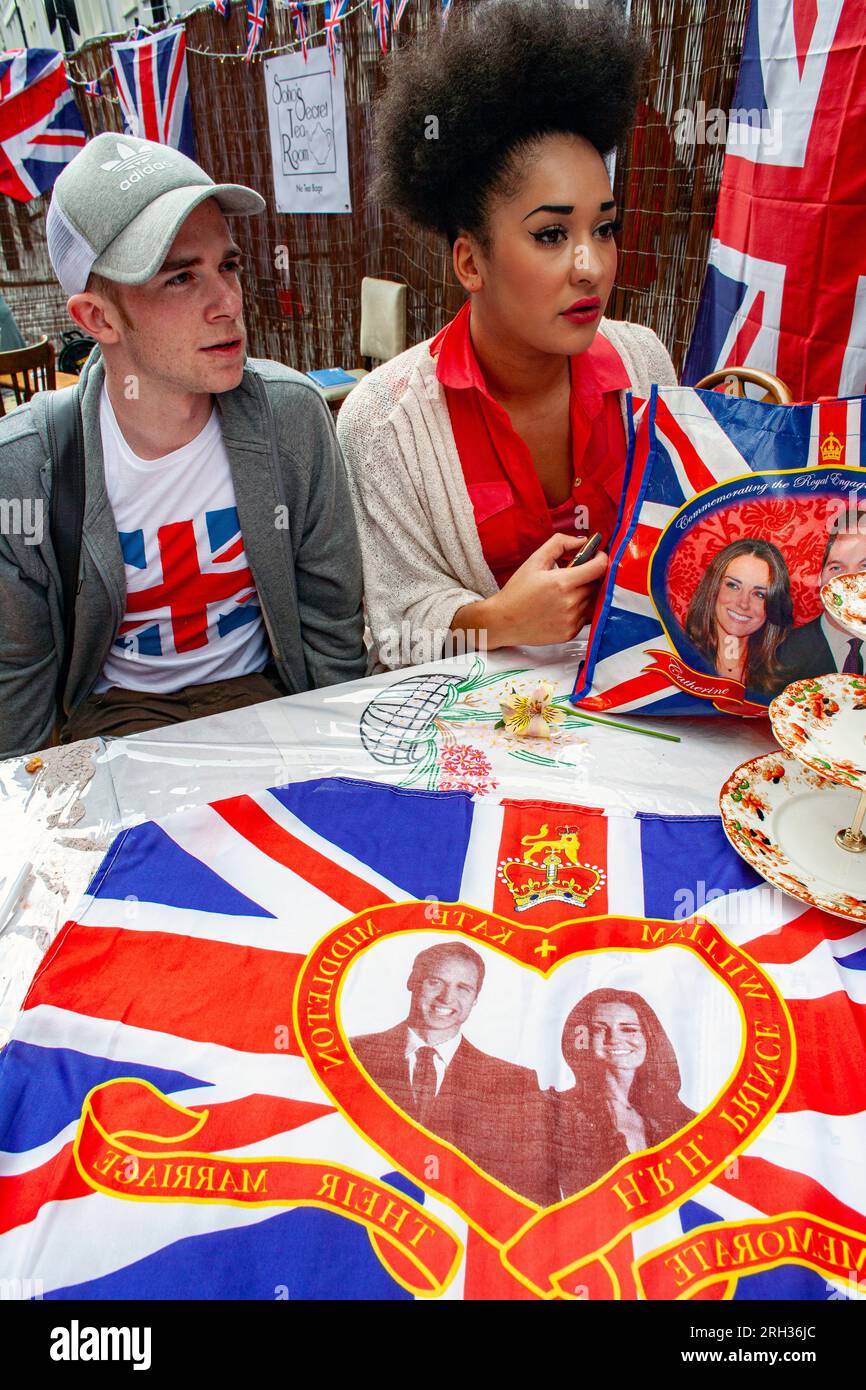 Young couple sitting at table at street party in Soho London on Royal Wedding day in London,United Kingdom , Stock Photo