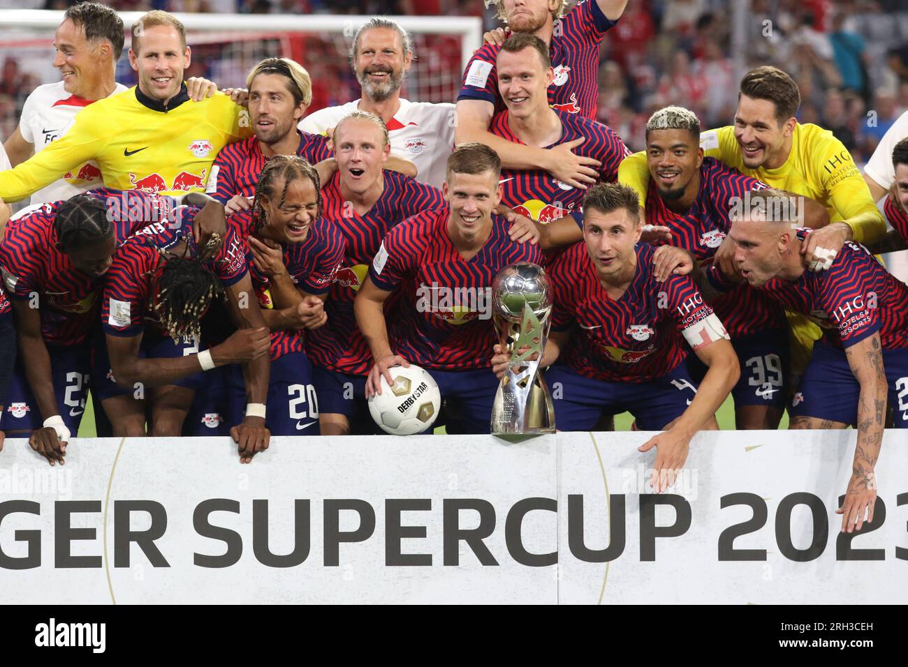 MUNICH, Germany - 12. AUGUST 2023: 4 Willi Orban (C) with trophy, RB Leipzig players celebrate with the winners trophy after winning the Supercup 2023 match between FC Bayern München and RB Leipzig at Allianz Arena on August 12th in Munich, Germany. DFL, Fussball, 0:3 (Photo and copyright @ ATP images/Arthur THILL Fc RB-LEIPZIG players and substitutes for this match: 21 Janis Blaswich (Keeper), 2 Mohamed Simakan, 4 Willi Orban (C), 7 Dani Olmo, 11 Timo Werner, 17 Lois Openda, 20 Xavi Simons, 22 David Raum, 24 Xaver Schlager, 39 Benjamin Henrichs, 44 Kevin Kampl, 9 Yussuf Poulsen, 10 Emil Stock Photo