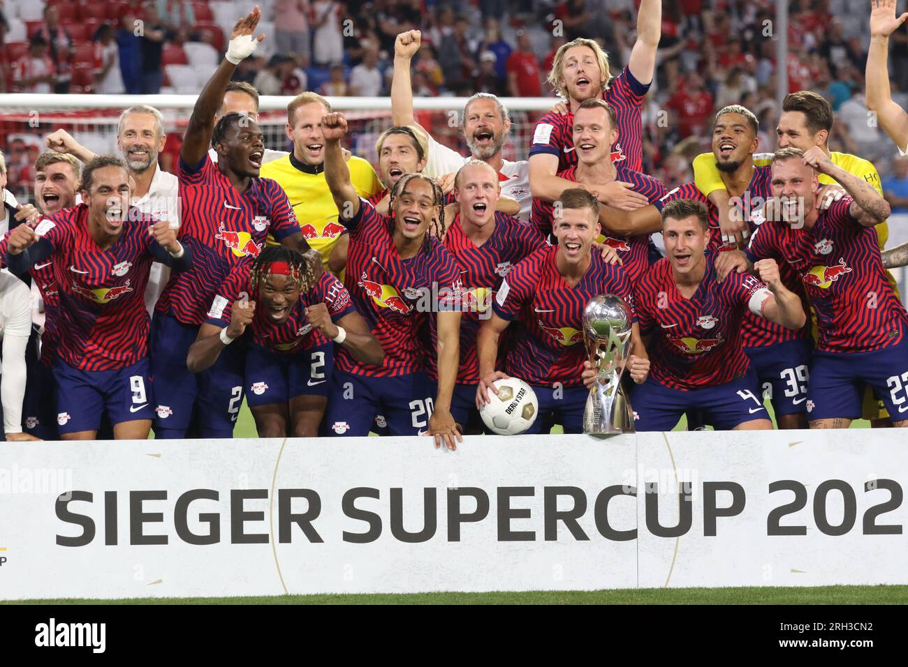 MUNICH, Germany - 12. AUGUST 2023: 4 Willi Orban (C) with trophy, RB Leipzig players celebrate with the winners trophy after winning the Supercup 2023 match between FC Bayern München and RB Leipzig at Allianz Arena on August 12th in Munich, Germany. DFL, Fussball, 0:3 (Photo and copyright @ ATP images/Arthur THILL Fc RB-LEIPZIG players and substitutes for this match: 21 Janis Blaswich (Keeper), 2 Mohamed Simakan, 4 Willi Orban (C), 7 Dani Olmo, 11 Timo Werner, 17 Lois Openda, 20 Xavi Simons, 22 David Raum, 24 Xaver Schlager, 39 Benjamin Henrichs, 44 Kevin Kampl, 9 Yussuf Poulsen, 10 Emil Stock Photo