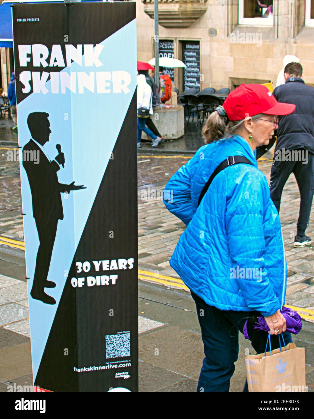 Edinburgh, Scotland, UK. 13h  August, 2023. UK WeatherFrank Skinner: 30 Years of Dirt A very busy royal mile with performers and tourists. Warm and wet as tourists infested the streets of the city amongst the street fringe acts with their brollies . Credit Gerard Ferry/Alamy Live News Stock Photo